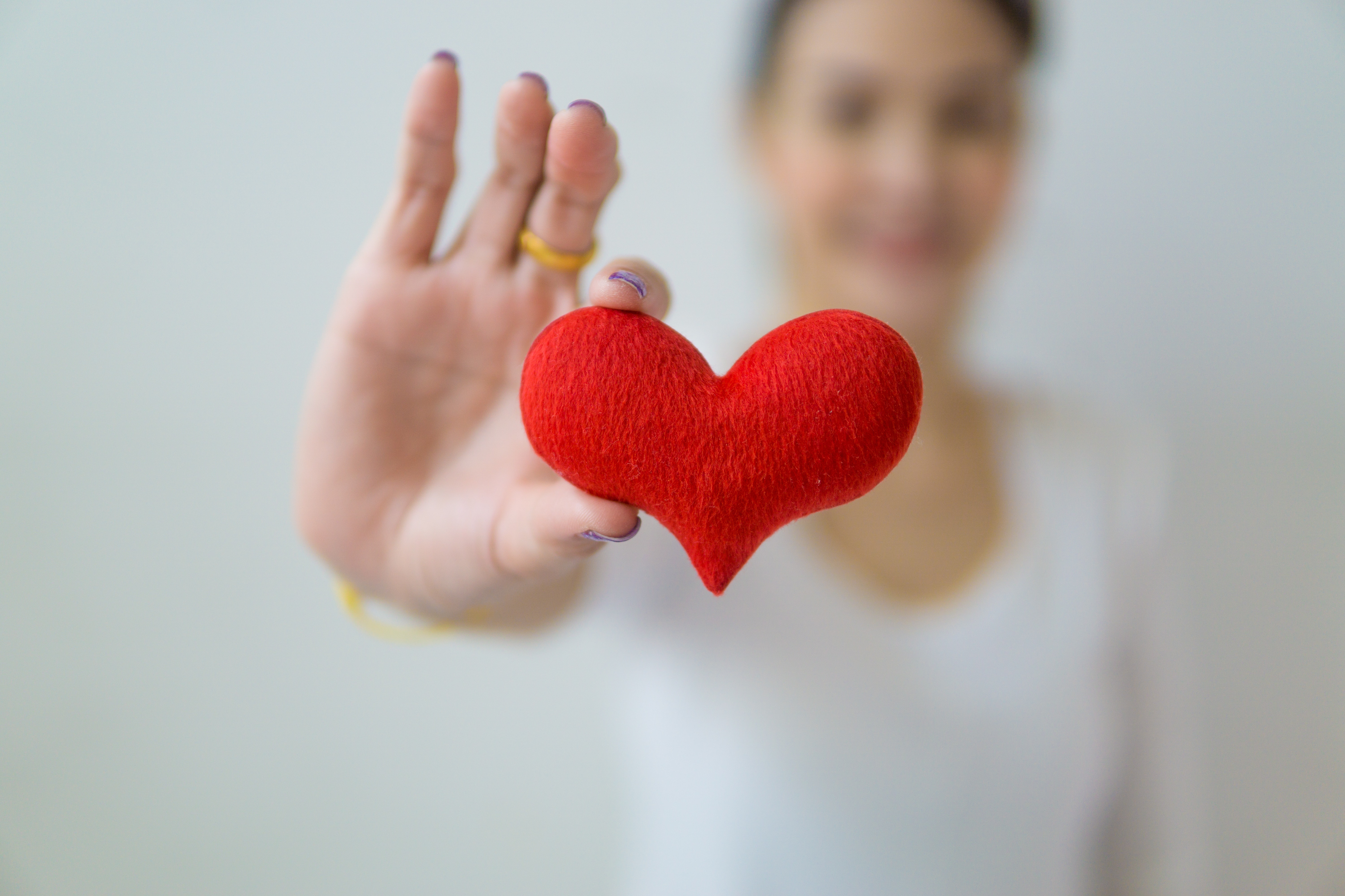 A person holding a heart made from fabric